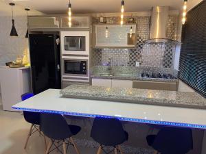cocina con encimera blanca y sillas azules en Casa para Show Rural Flat Sobrado, en Cascavel
