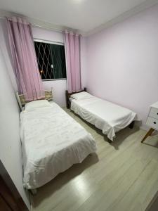 2 camas en una habitación pequeña con ventana en Casa para Show Rural Flat Sobrado, en Cascavel