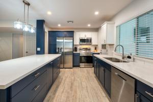 a large kitchen with white cabinets and blue appliances at Casa Bonita - Pool, Casita, Walk to ASU and Mill in Tempe