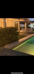 a swimming pool in front of a building with tables and chairs at Suite’s Pool in Yelateni