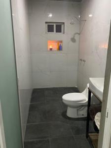 a small bathroom with a toilet and a sink at Suite’s Pool in Yelateni