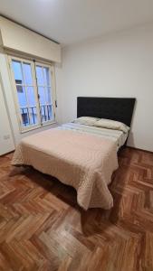 una camera con un grande letto e pavimenti in legno di Balcones del Este a Córdoba