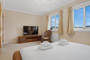 1 dormitorio con 1 cama con toallas plegables. en Taigh d'Luxe en Inverness