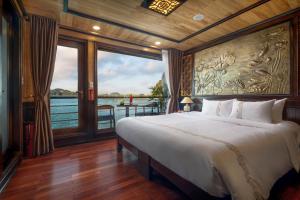 a bedroom with a bed and a view of the water at V'Spirit Cruises in Ha Long