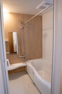 a bathroom with a bath tub and a shower at Second Home 瀬戸風月 in Takamatsu