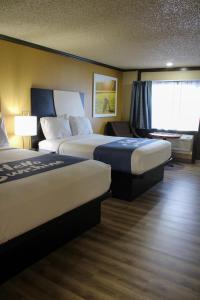 a hotel room with two beds and a window at Days Inn by Wyndham Bend in Bend