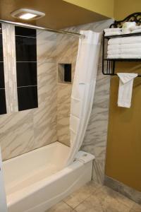 a bathroom with a shower with a tub and a toilet at Days Inn by Wyndham Bend in Bend