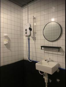 a bathroom with a shower and a sink and a mirror at SABAYA HOMESTAY in Balik Pulau