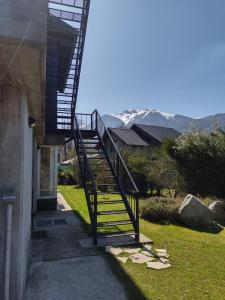 una escalera que conduce a una casa con montañas en el fondo en ALOJAMIENTOS PATAGONICOSEl Estudio VLA en Villa La Angostura