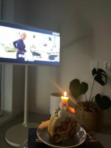 a cake with a candle on a table with a television at Tongyeong Canal Ocean View in Tongyeong