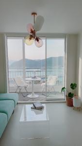 a living room with a blue couch and a ceiling fan at Tongyeong Canal Ocean View in Tongyeong