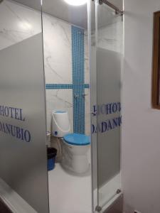 a bathroom with a toilet and a glass shower door at HOTEL DANUBIO in Bogotá