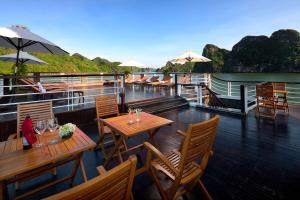 a deck with tables and chairs on a boat at V'Spirit Cruises in Ha Long