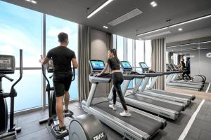 a man and a woman on a treadmill in a gym at Holi Panorama Nha Trang in Nha Trang