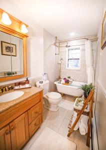 a bathroom with a tub and a toilet and a sink at Infinity MountView House in Sussex +29 photos