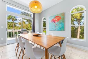uma sala de jantar com uma mesa de madeira e cadeiras brancas em Enjoy a stress free vacation at this 3BR paradise em Sarasota