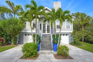 een wit huis met palmbomen ervoor bij Enjoy a stress free vacation at this 3BR paradise in Sarasota