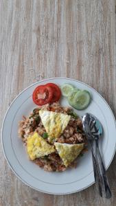 un plato de comida con huevos, arroz y tomates en D'SARI UNDISAN Houses, en Bangli