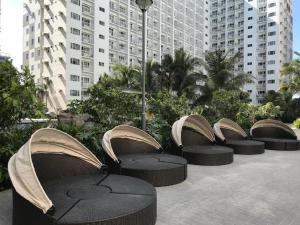 a row of tables and chairs with buildings in the background at Shore Residences in Manila