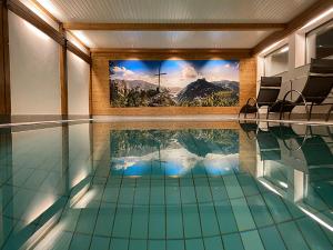 uma piscina com uma grande pintura na parede em Haus Jäger Ferienwohnungen mit Indoor-Pool em Ruhpolding