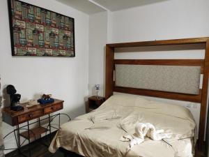 a bedroom with a bed with a wooden headboard and a table at Ex Hacienda Santa Elena in Atlixco