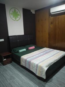 a bedroom with a bed and a wooden wall at CEMPAKA CHALETS TIOMAN in Kampong Juara