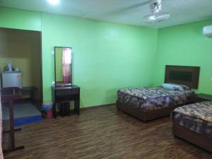 a room with two beds and a table and a mirror at CEMPAKA CHALETS TIOMAN in Kampong Juara