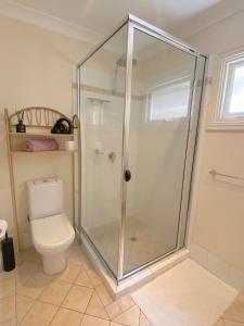 uma cabina de duche na casa de banho com WC em Cosy Haven For Females Only or Females & Child/ren em Brisbane