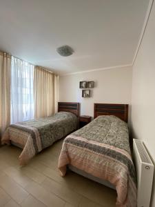 Un dormitorio con dos camas y una ventana. en Solvallerios Viña Centro, en Viña del Mar
