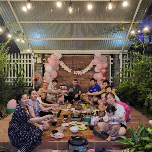 eine Gruppe von Menschen, die um einen Tisch sitzen in der Unterkunft Thuy Tien Ecolodge in Cat Tien