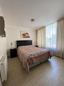 Un dormitorio con una cama y una ventana grande. en Solvallerios Viña Centro, en Viña del Mar