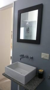 y baño con lavabo blanco y espejo. en Moderno departamento con balcón en Recoleta en Buenos Aires