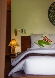 a bedroom with a bed and a lamp on a table at Cadlao Resort and Restaurant in El Nido