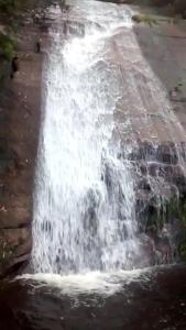 a waterfall on the side of a road at Bangalô - Sítio Cachoeiras do Caledônia in Nova Friburgo