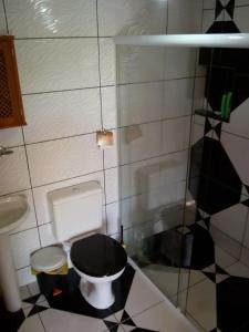 a bathroom with a black and white toilet and a sink at Bangalô - Sítio Cachoeiras do Caledônia in Nova Friburgo