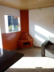 a living room with a couch and a window at Bangalô - Sítio Cachoeiras do Caledônia in Nova Friburgo