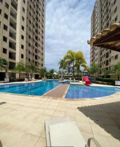 a large swimming pool with two tall buildings at Belíssimo apartamento inteiro in Aracaju