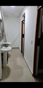 Cette chambre blanche dispose d'un lavabo et d'un miroir. dans l'établissement Finca Pradera Real, à Circasia