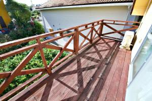 eine Terrasse mit einem Holzgeländer auf einem Haus in der Unterkunft 川平ハウス in Onna