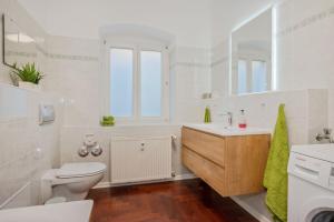 a white bathroom with a toilet and a sink at Villa Meereswoge - Goldstern in Bansin