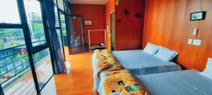 eine Reihe von Betten in einem Zimmer mit Balkon in der Unterkunft Daisy Homestay Tam Dao - Venuestay in Vĩnh Phúc