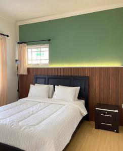 1 dormitorio con 1 cama grande con sábanas blancas en Green Apple Villa, en Batu