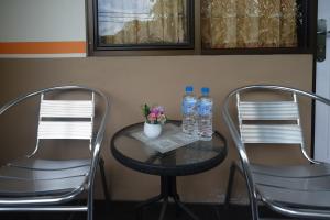 duas cadeiras e duas garrafas de água numa mesa em RedDoorz @ Jalan Pramuka Manado em Manado
