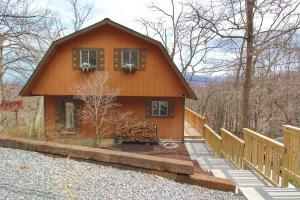 a small house with a porch and a fence at Paradise Vista, Amazing Mtn Views, Hot Tub, 560 FREE tickets each paid day!!! in Gatlinburg