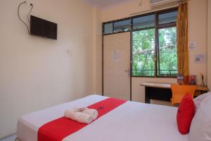 um quarto com 2 camas, uma secretária e uma janela em RedDoorz @ Jalan Pramuka Manado em Manado