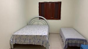 a room with two beds and a window at Casa pedrinhas in Ilha Comprida