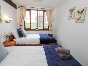 sypialnia z 2 łóżkami i oknem w obiekcie Condicote Cottage w mieście Weston on Avon