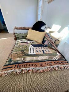 a bed with a blanket with a house on it at Peddlers Carriage house in New Hope