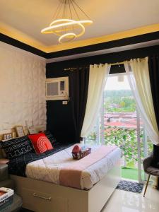 een slaapkamer met een bed en een groot raam bij Azehr's Walk Up and Cozy Condo in Minglanilla