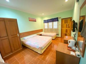 a small bedroom with two beds and a desk at PANGKOR PURNAMA CHALET in Pangkor